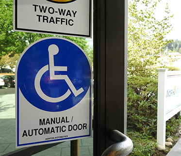 Manual automatic door with wheel chair accessibile sign