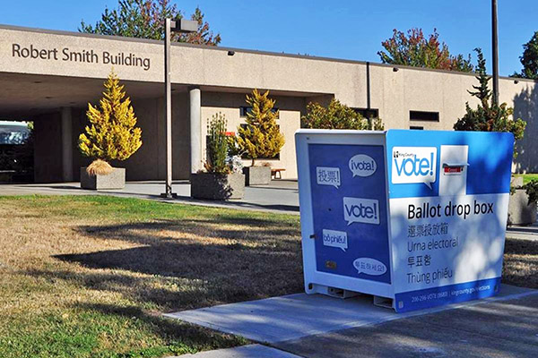 Ballot drop box with the Rober Smith Building in the background.