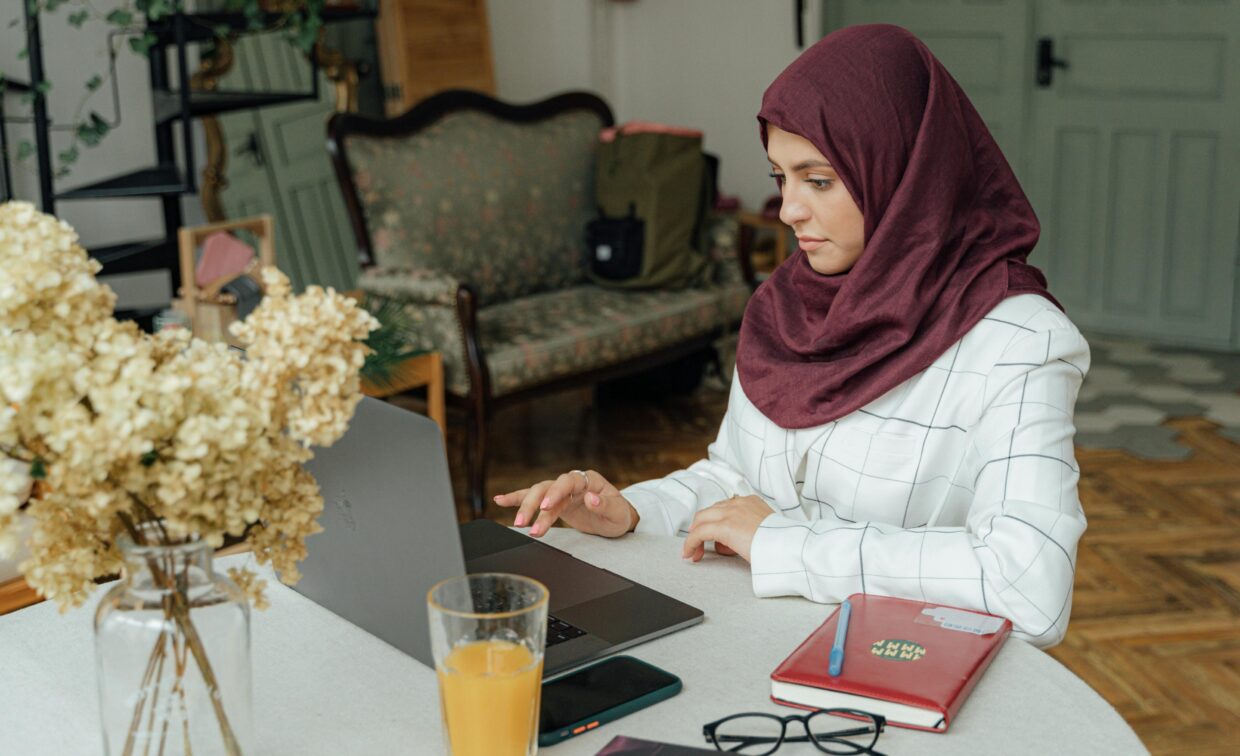 woman in hijab works on computer