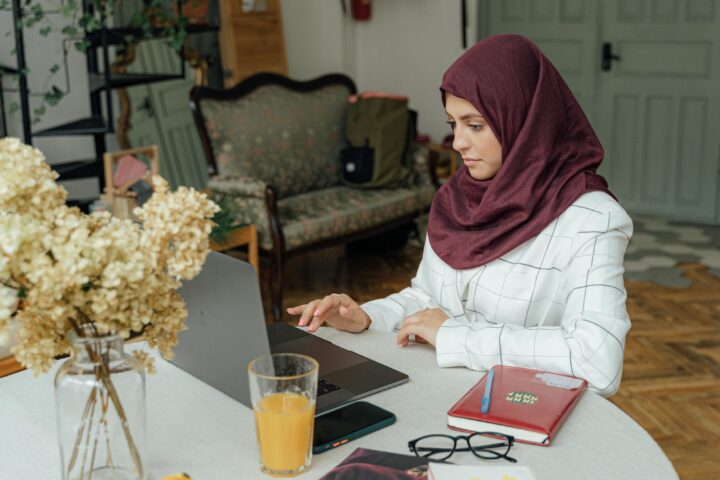 woman in hijab works on computer